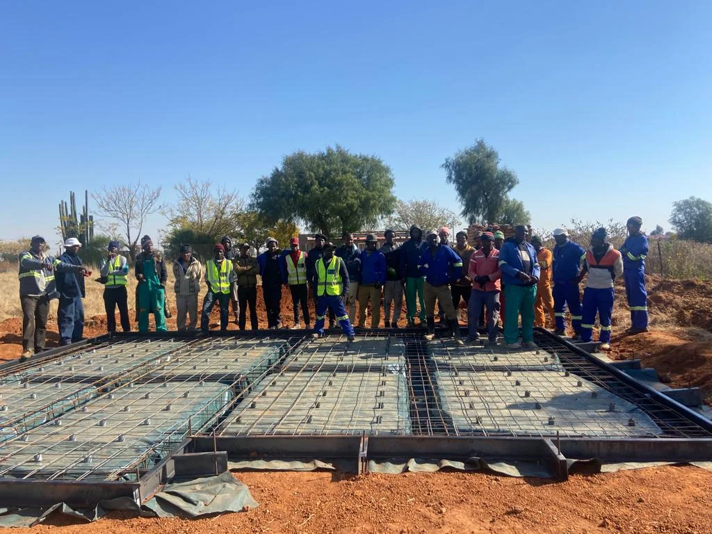 Construction team standing behind reinforced slab work